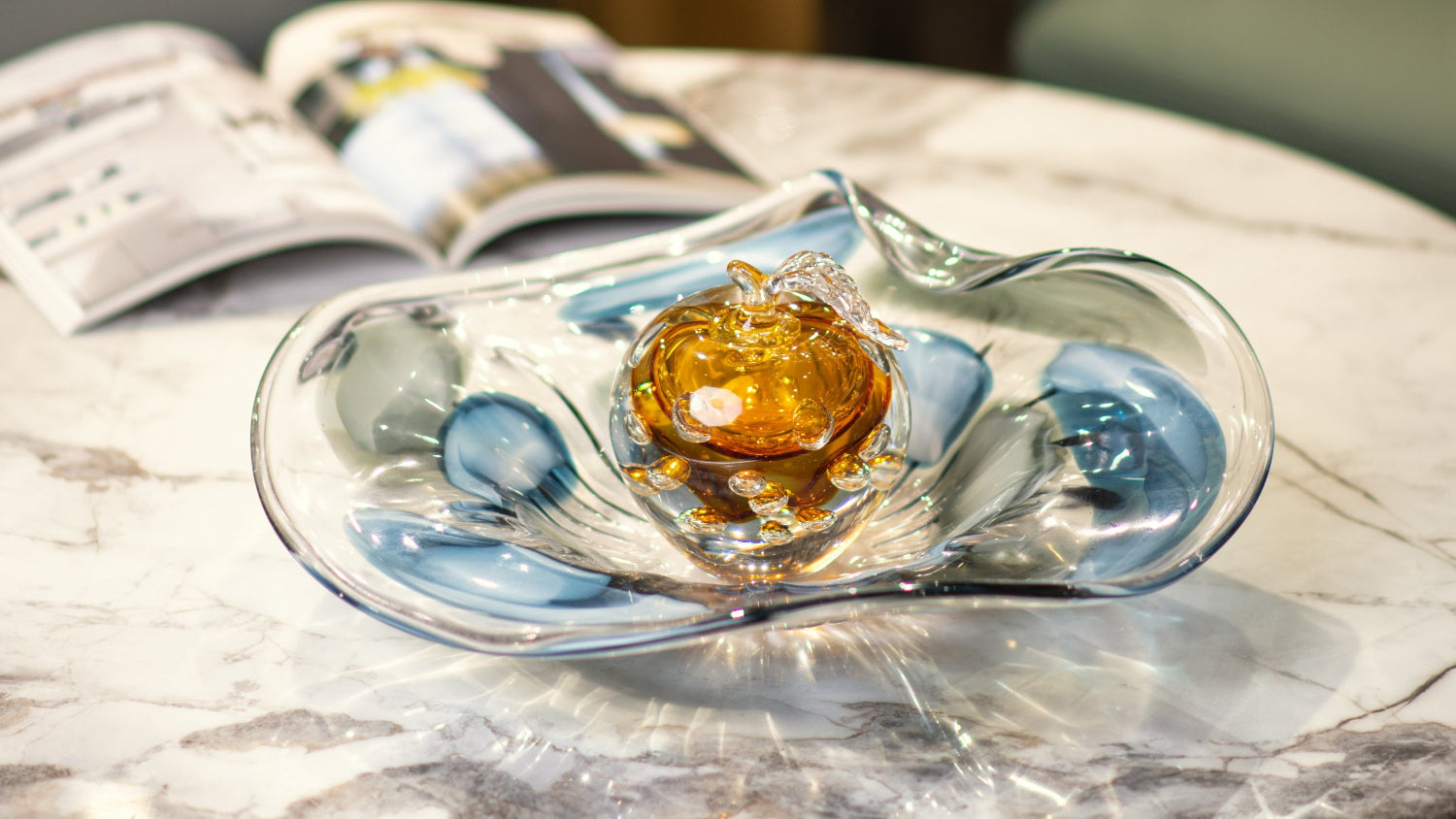 Glass dish with a decorative item on a marble surface